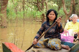 Ms. Chum Kreun taking tourists on a boat tour in the flooded forest in Kampong Phluk floating community.